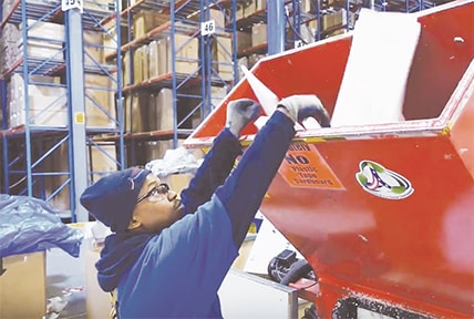 Man shredding Styrofoam for recycling at AFW warehouse
